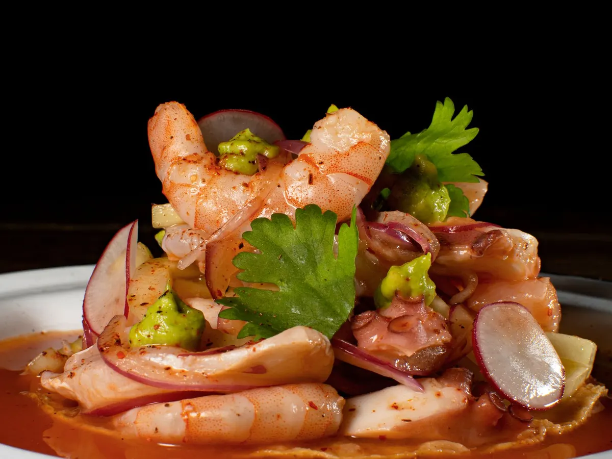 Platón de camarón y pulpo en salsa picante, servido a media luz