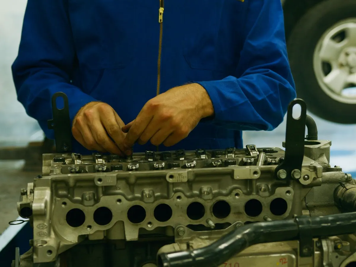 Técnico revisando el motor abierto de un vehículo en el taller